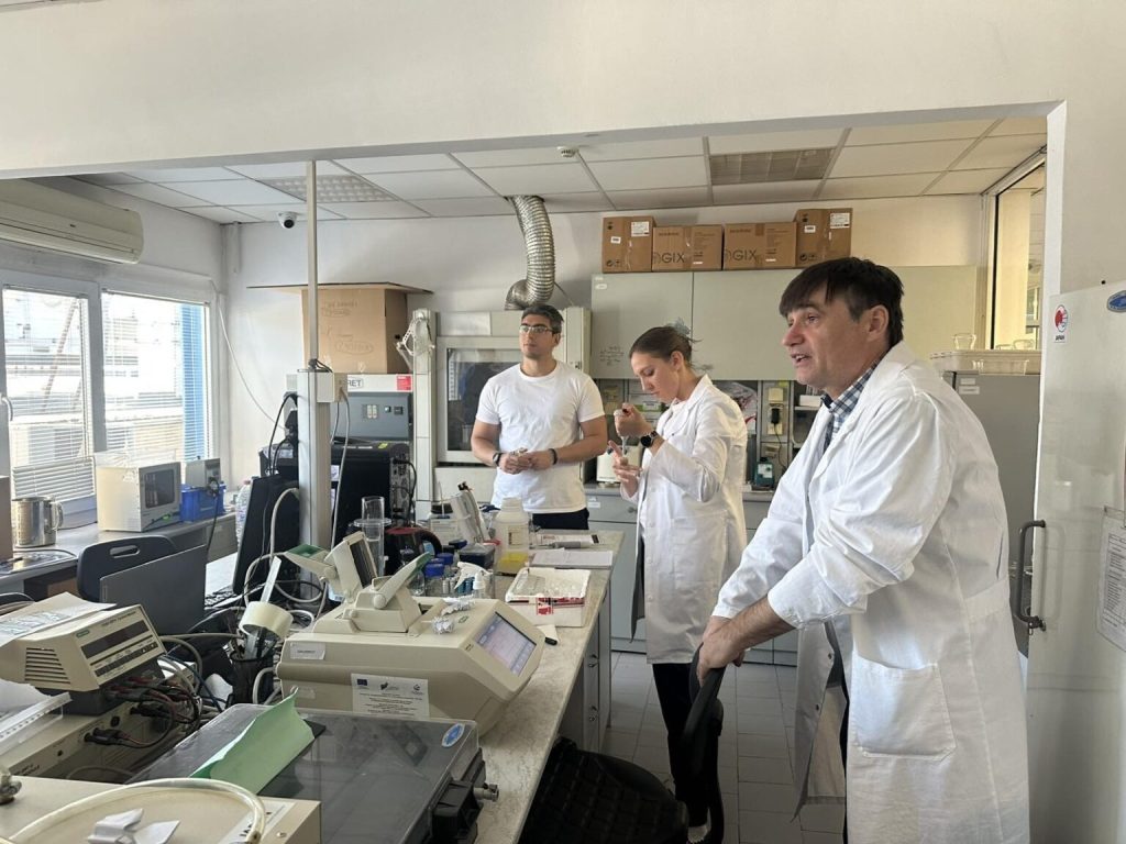Ученици в лаборатория по микробиология с микроскоп и етикет „Streptococcus thermophilus“ – символ на образованието чрез практика