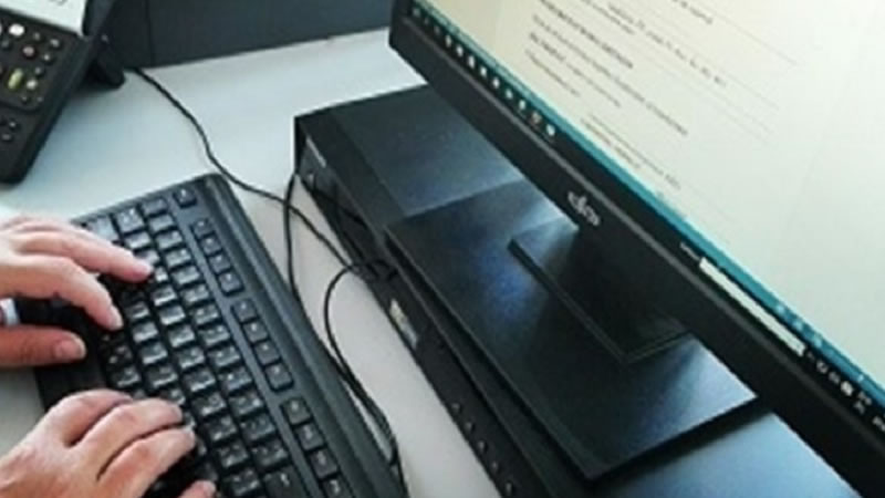 Земеделец използва лаптоп на полето, преглеждайки уведомително писмо в профила си в СЕУ – символ на дигитализацията в администрирането на агроекологичните интервенции